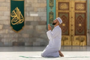 Man praying in front of Masjid Nabawi’s golden gate – Ziyarat Places in Madinah